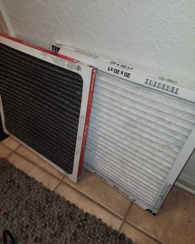 home therapist cooling heating and plumbing replacing air filters with two new hvac filters laid on a tile floor