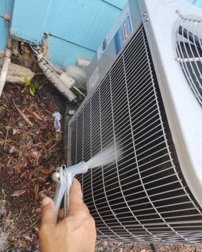 home therapist cooling heating and plumbing cleaning an outdoor air conditioning unit using a pressurized water spray