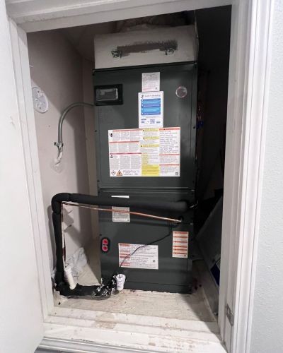 heating system installation with visible pipes and connections in a residential closet space