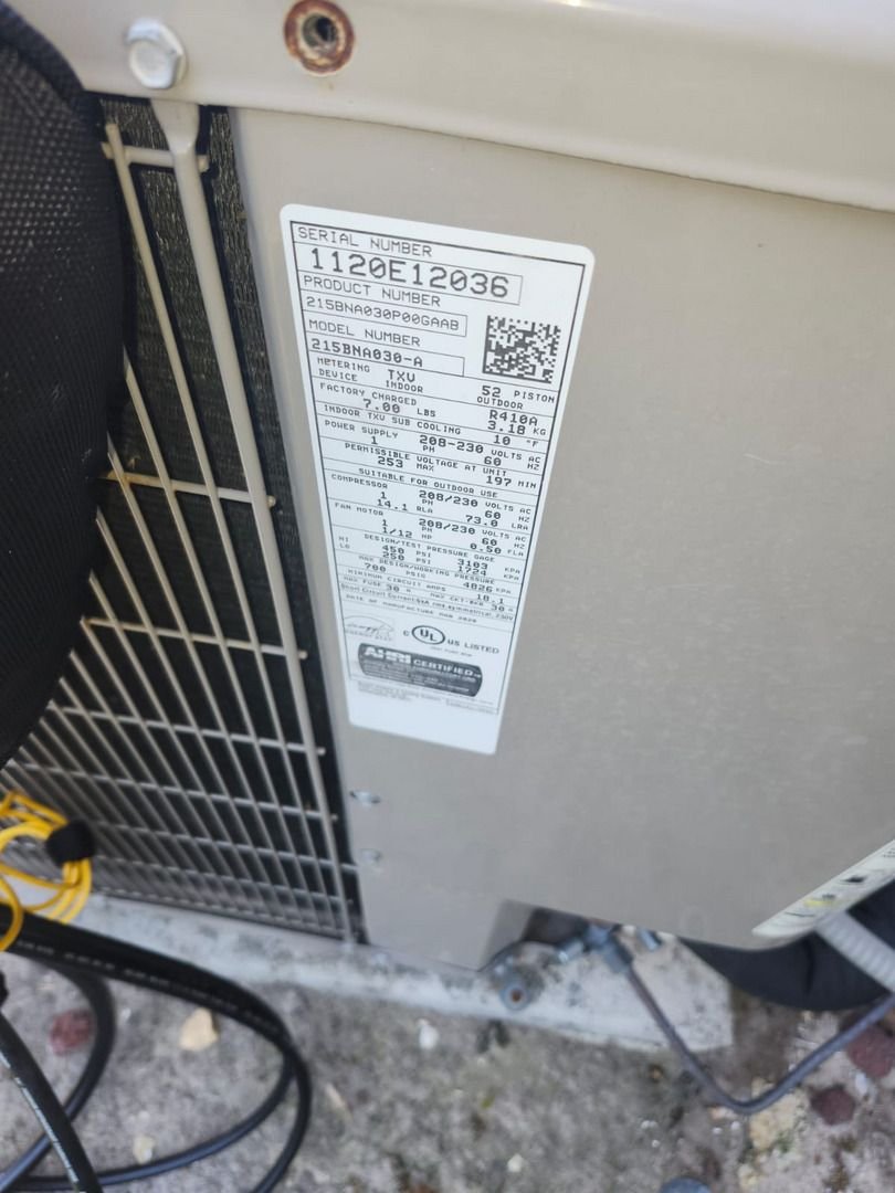Home Therapist Cooling Heating And Plumbing Inspecting An Air Conditioning Unit With A Focus On Model And Serial Number Details