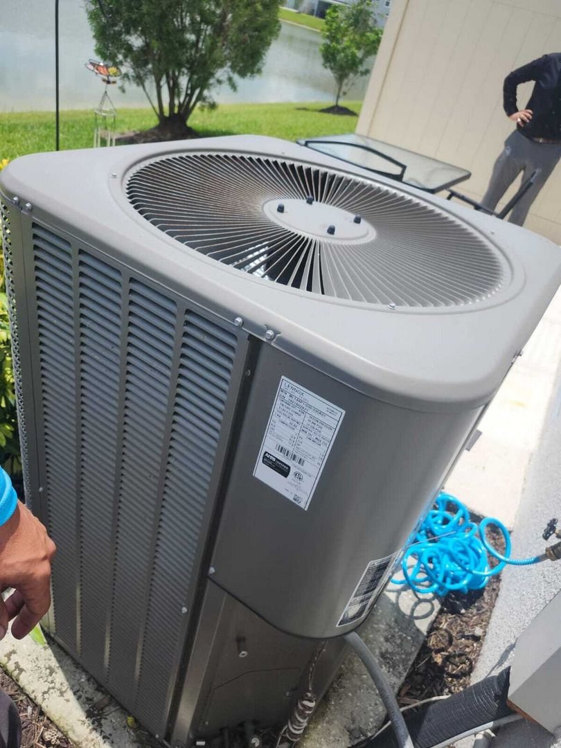 home therapist cooling heating and plumbing performing maintenance on an outdoor air conditioning unit with tools nearby