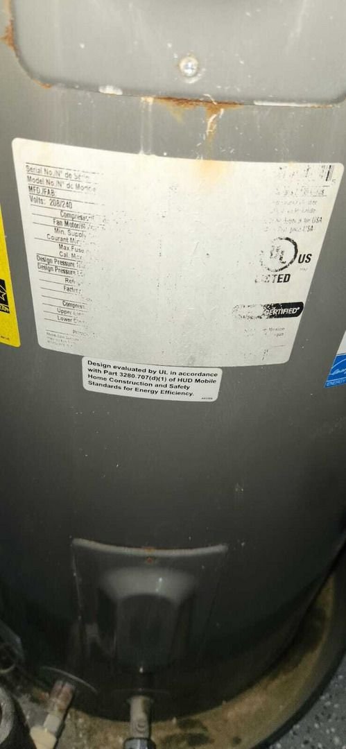 home therapist cooling heating and plumbing servicing a water heater displaying labels and connections on a gray tank