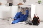 Woman Fixing Sink In Kitchen With Tools And Equipment