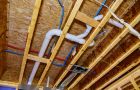 Plumber Pipes And Wooden Beams In Construction Ceiling