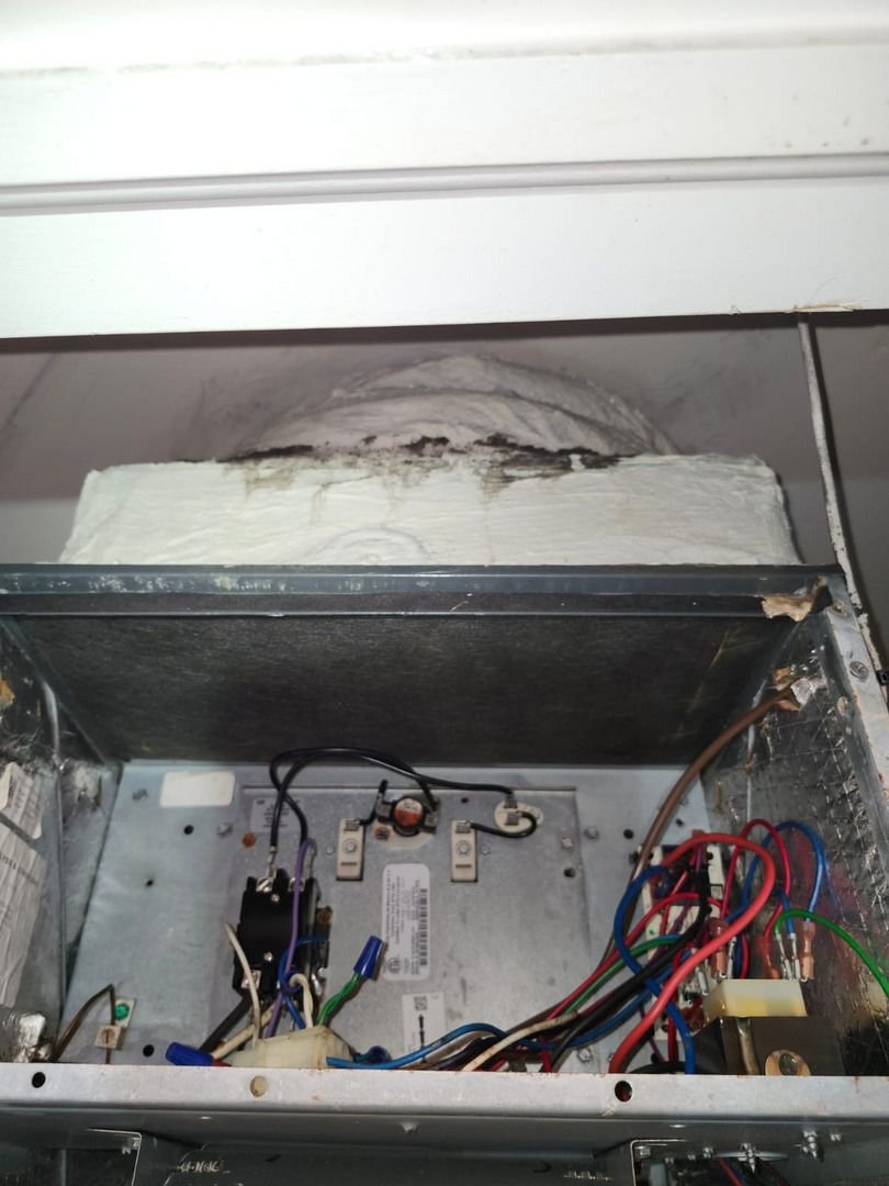 electric panel with visible wiring connections inside an HVAC unit potentially indicating maintenance or repair work being performed
