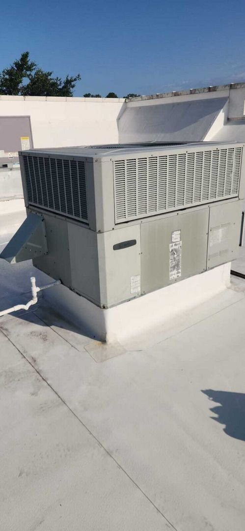 home therapist cooling heating and plumbing servicing an hvac unit on a flat rooftop with a clear blue sky