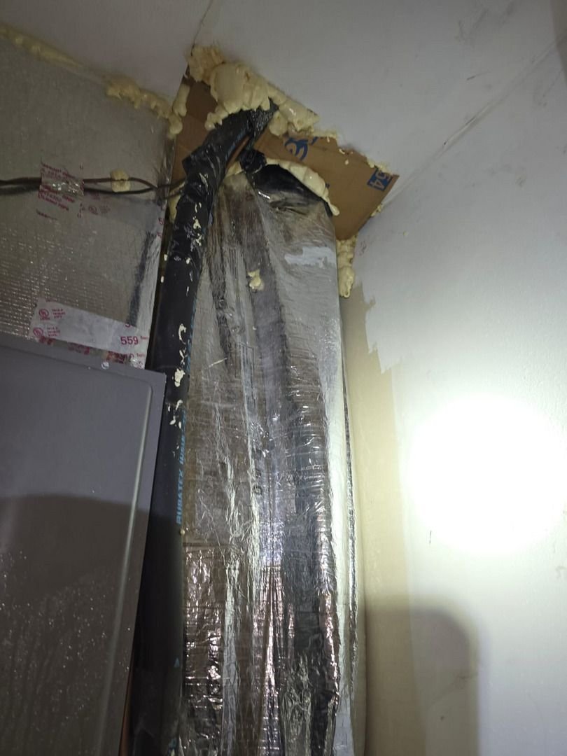 insulation installation in ductwork with foam sealant around joints and a reflective material on the ducts