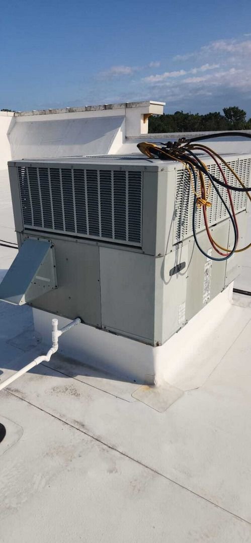 home therapist cooling heating and plumbing inspecting or servicing an outdoor air conditioning unit on a flat roof