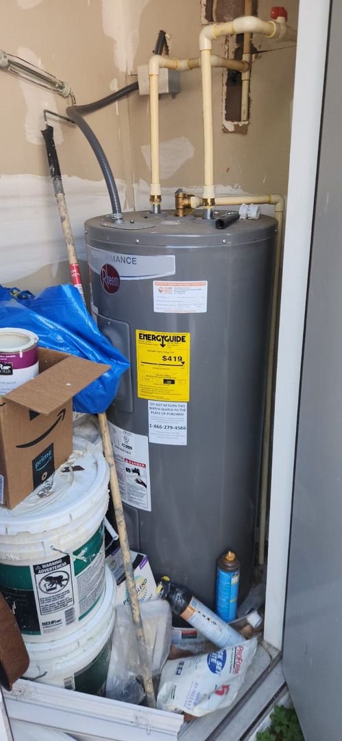 water heater installation with various tools and materials nearby cluttered storage area visible