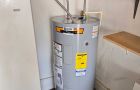 Water Heater In Utility Room With Connected Pipes And Valves