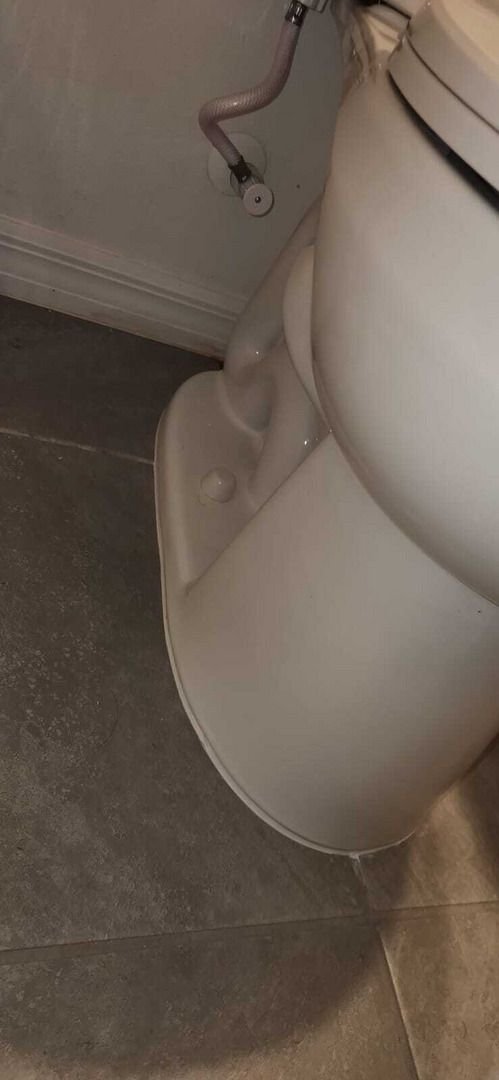 toilet installation in a bathroom with visible plumbing connections and ceramic tile flooring