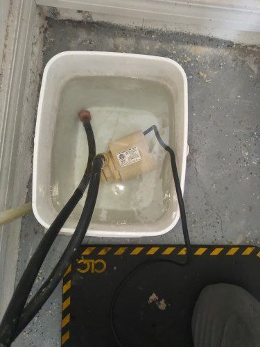 Tankless water heater descaling flush with a pump and bucket in Tampa, FL