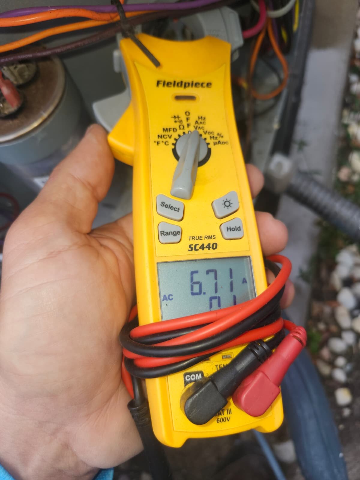 AC maintenance visit in Lutz, FL 33549 inspecting outdoor condenser and capacitor