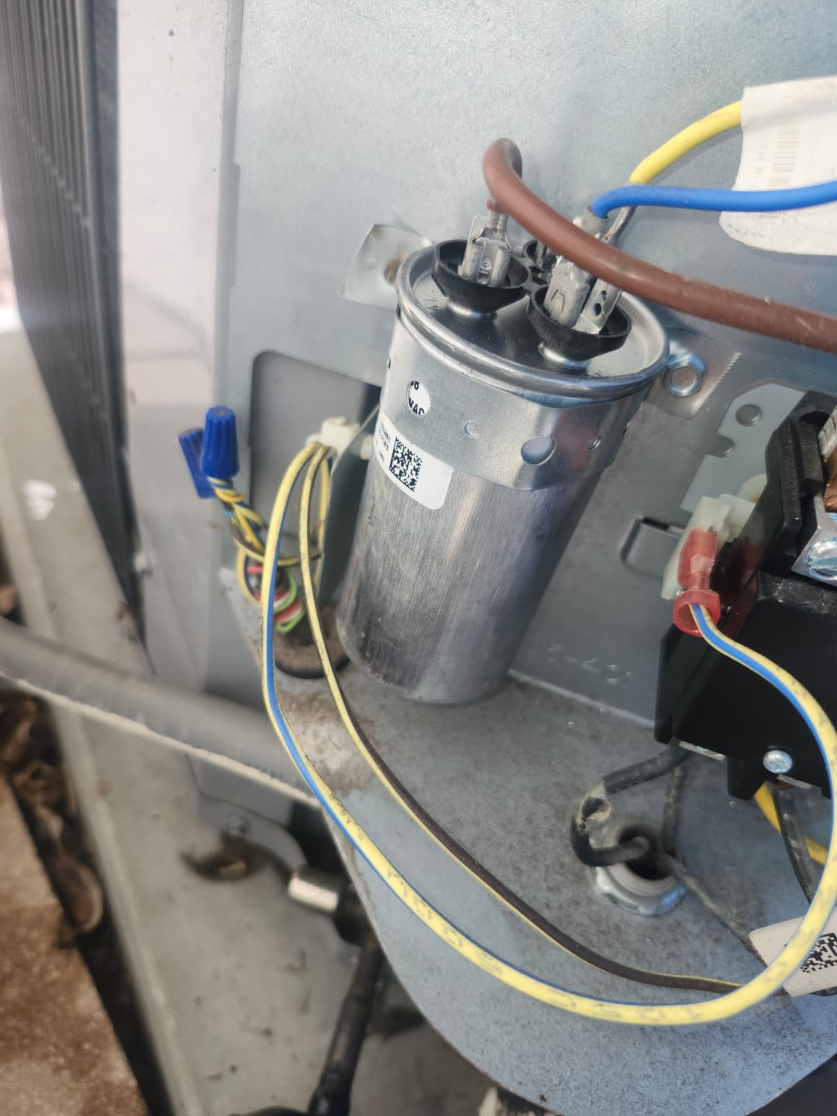 Technician inspecting AC capacitor during replacement in Tampa, FL 33618