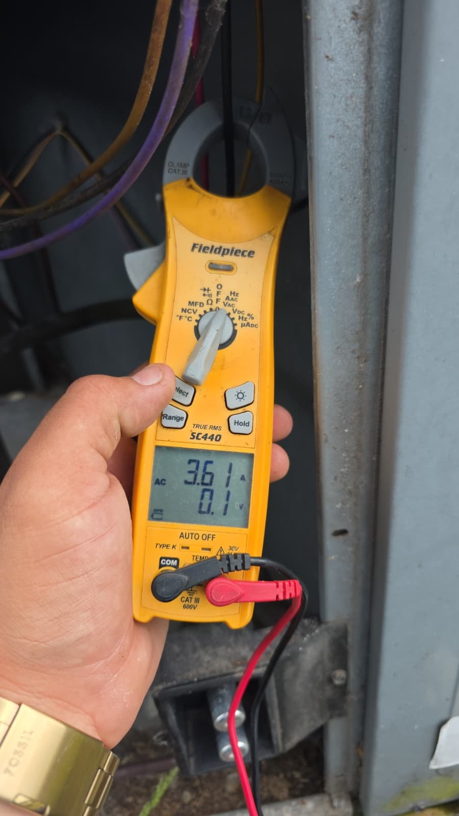Technician using a multimeter on AC unit for diagnosis in St. Petersburg, FL 33704.