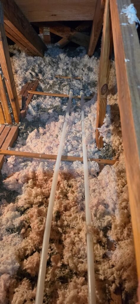New water supply lines run across the attic insulation in Tampa, FL 33624.