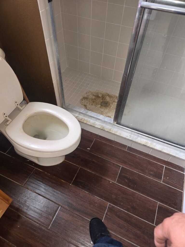 Clogged bathroom with toilet and shower in Tampa, FL 18318.