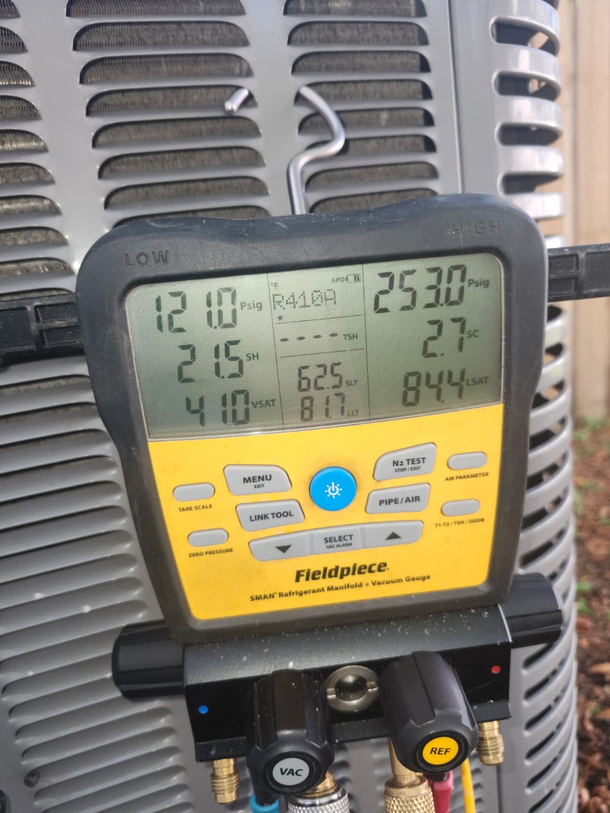Fieldpiece digital manifold gauge displaying R410A readings during capacitor replacement in Tampa, FL 33624.
