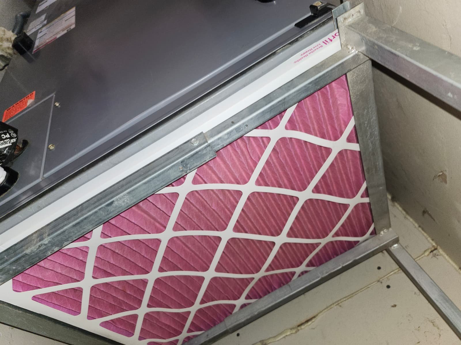 Close-up of pink air filter in HVAC system during Premium Therapy Plan in Plant City, FL 33563.