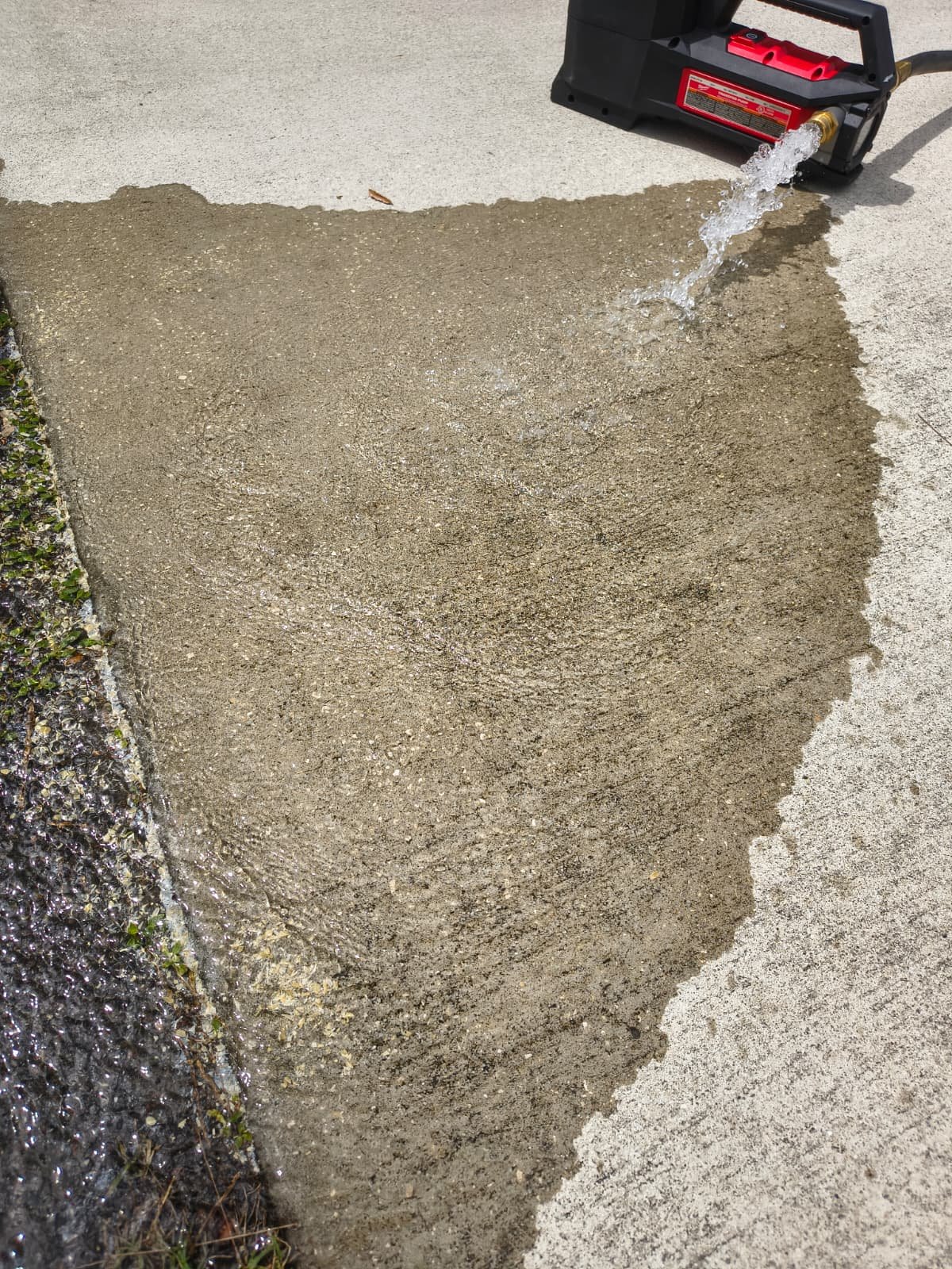 Pressure washing on concrete surface during plumbing service in Tampa, FL 33614.