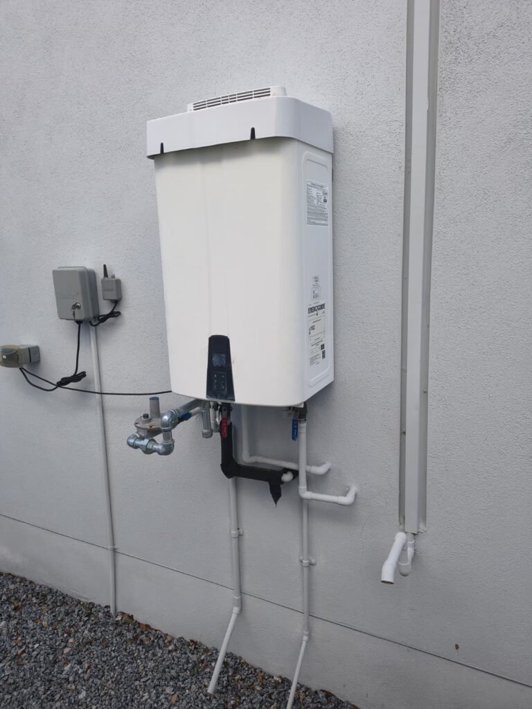 A tankless water heater and its water valves on an outside wall in Tampa, FL 33604.