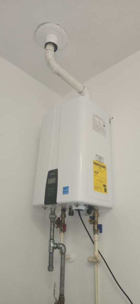 A new tankless water heater with its white vent pipe running up through the ceiling in Palm Harbor, FL 34684.