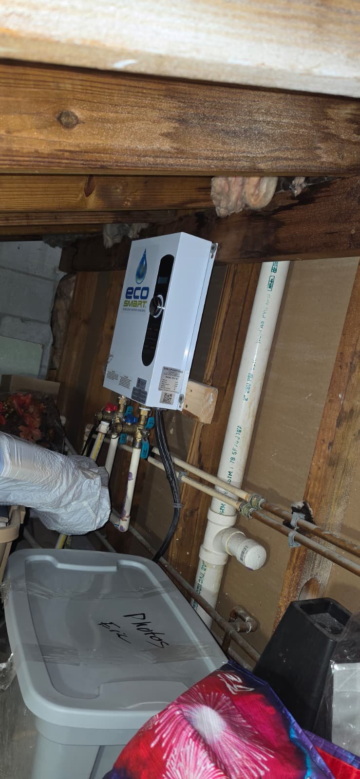 In-progress tankless water heater installation with plumbing connections in an attic in Tampa, FL 8715 Cove Ct.