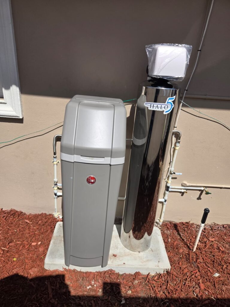 A Rheem cabinet softener and a stainless whole-home tank on a pad in New Port Richey, FL 34652.