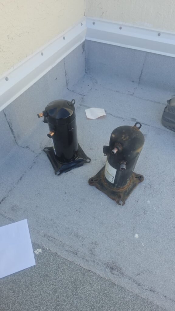 Old and new compressors on a rooftop during replacement in North Redington Beach, FL 33708.