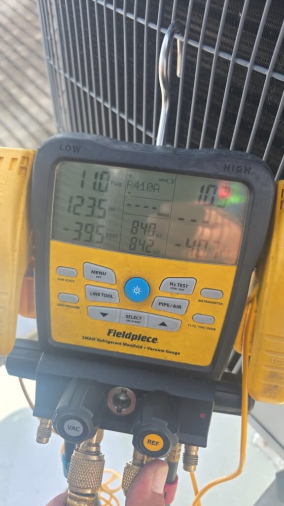 Fieldpiece gauge showing R410A levels during condenser coil replacement in Tampa, FL 33605.