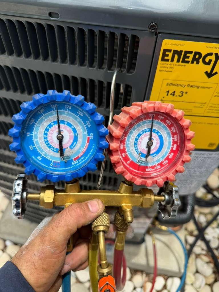 Technician with gauges in front of HVAC unit, Tampa, FL 33629.