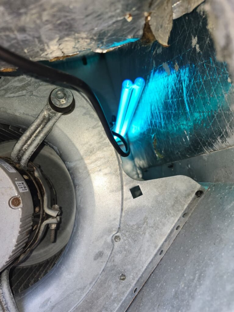 A UV-C lamp glowing next to the blower inside an air handler in Zephyrhills, FL.