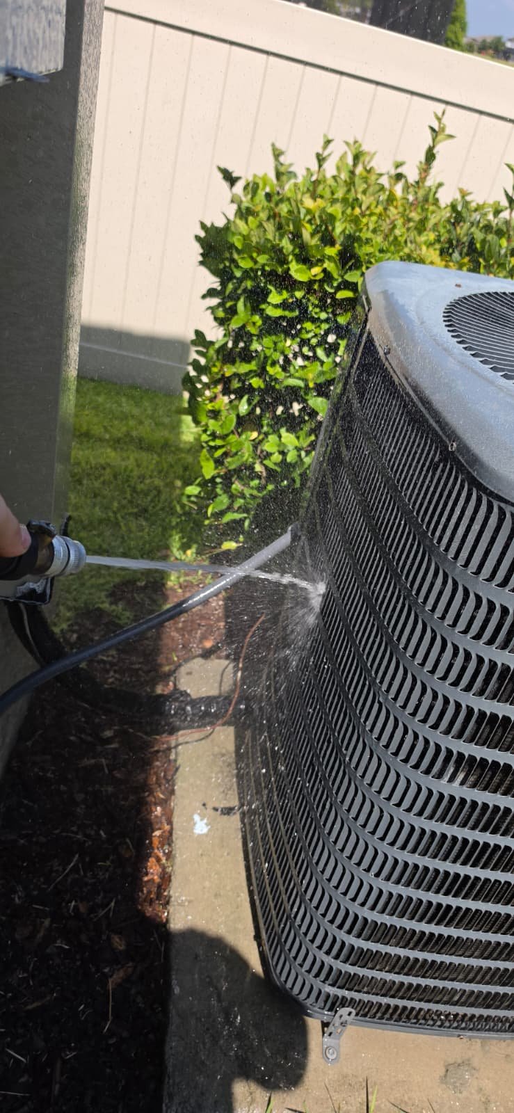 Close-up of water spraying on AC unit in Riverview, FL 33579.