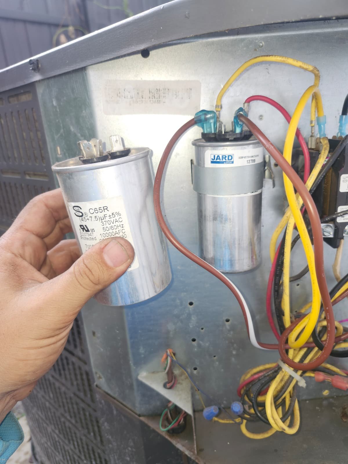 AC unit capacitor and wiring during system repair in Tampa, FL 33604.