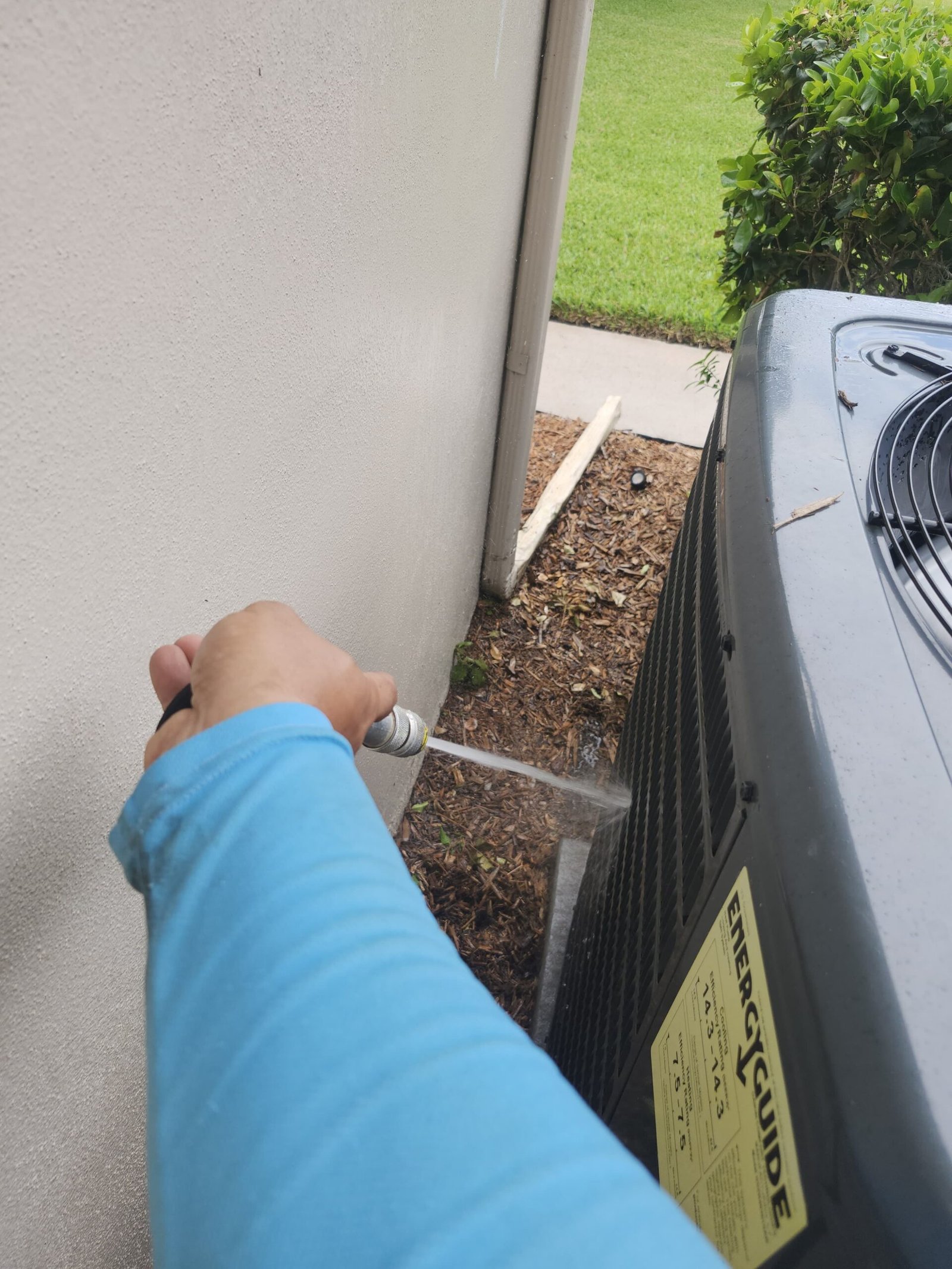 AC Unit Cleaning with Hose - Palm Harbor, FL 34684 Person cleaning outdoor AC unit with hose, Visit #4, Palm Harbor, FL 34684.