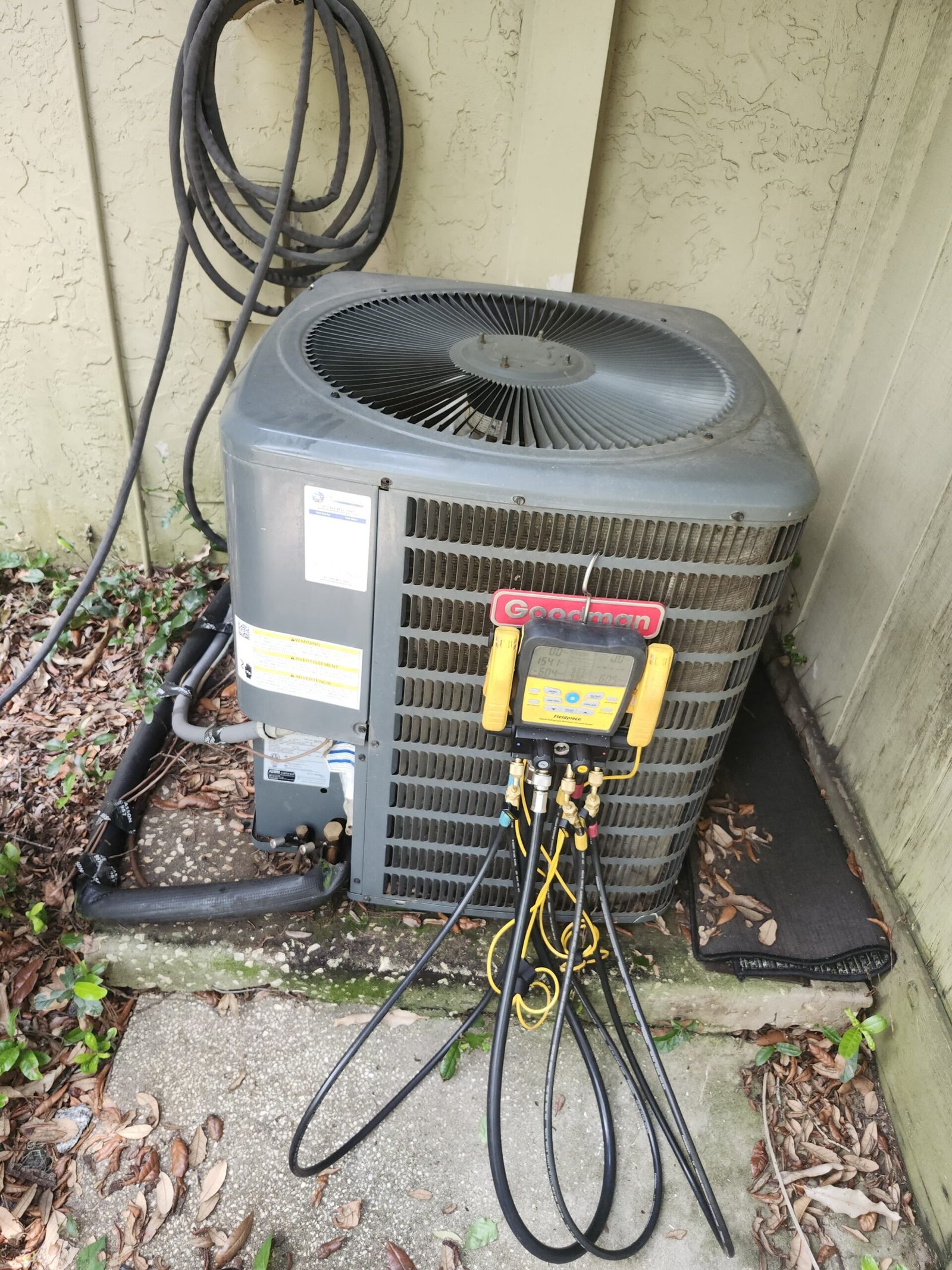 Outdoor AC unit with diagnostic tools attached in Lutz, FL 33559. Ensuring optimal performance.