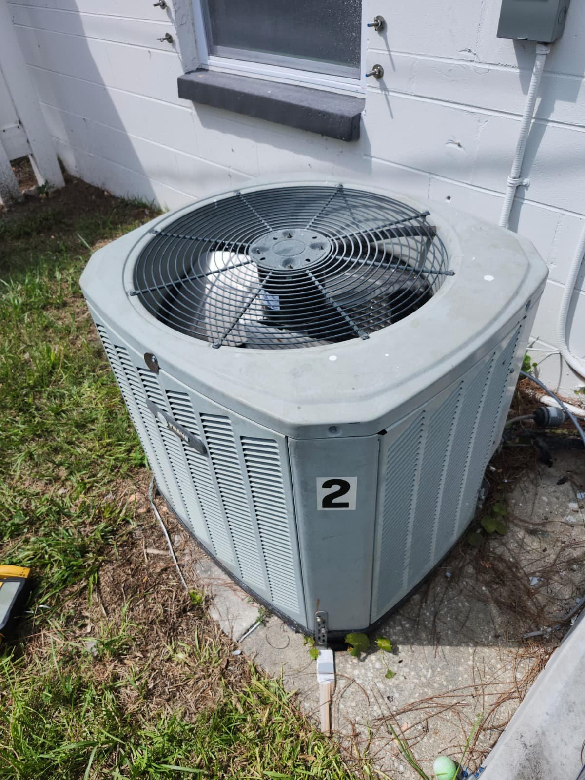 Exterior view of an air conditioning unit beside a house in St. Petersburg, FL 33712.