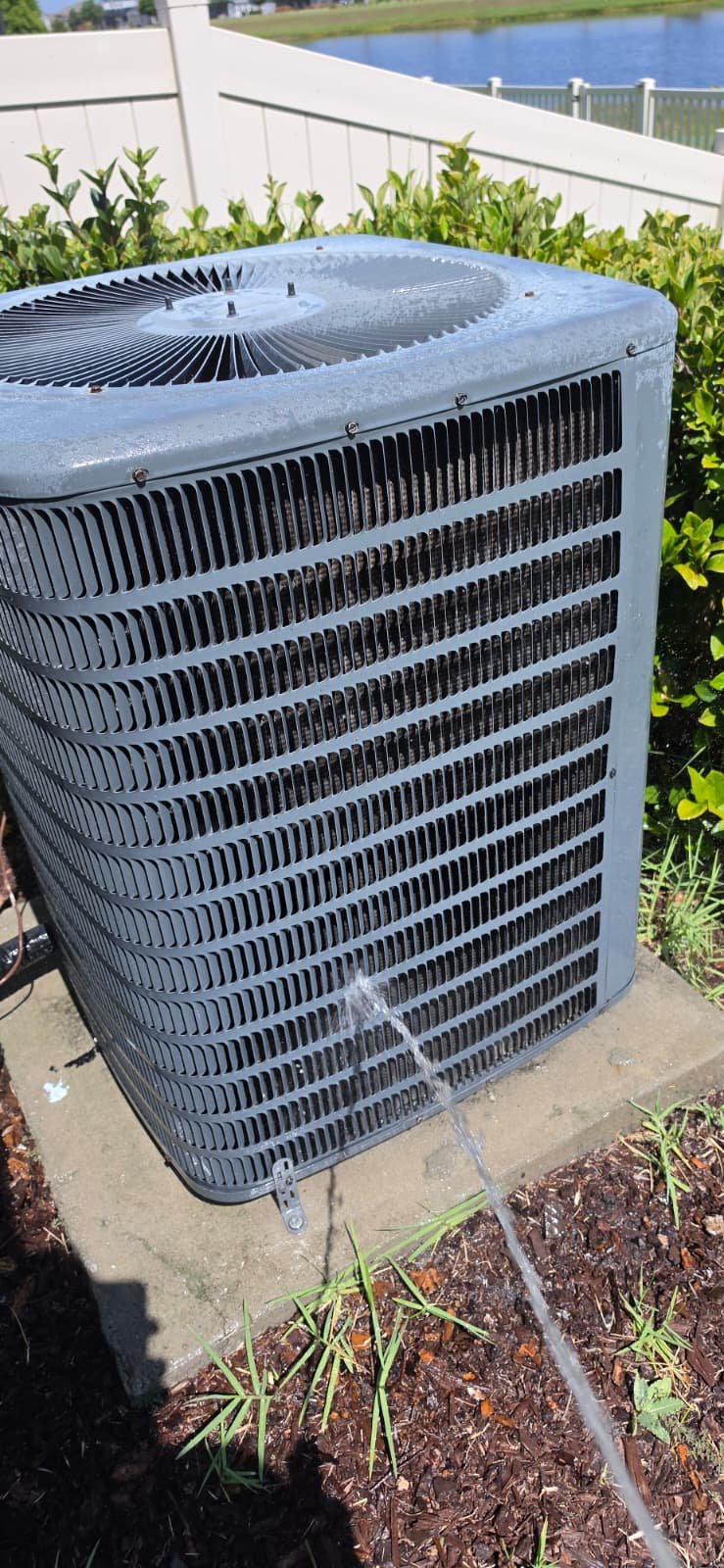 Outdoor AC unit being cleaned with water spray in Riverview, FL 33579.