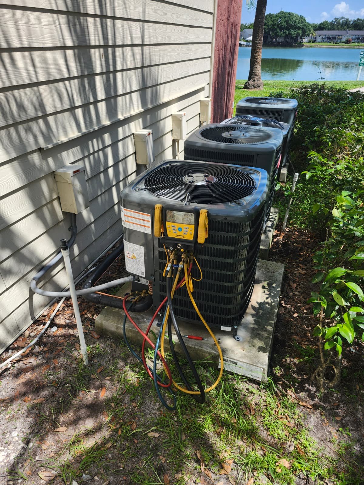 Outdoor AC units with testing gauges attached in Brandon, FL 33511. Ensuring optimal function.