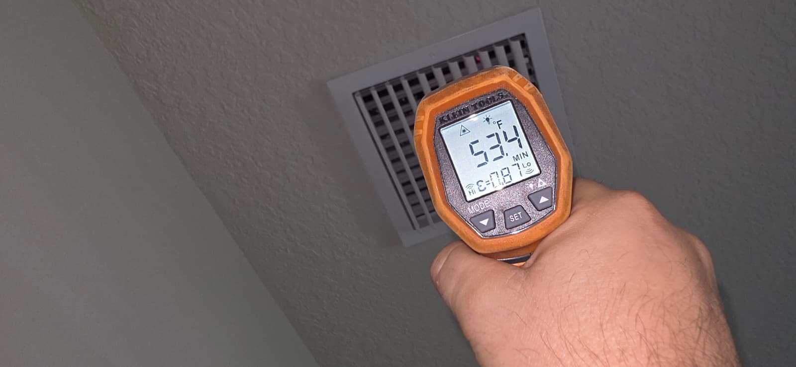 Infrared thermometer measuring air temperature at vent in Riverview, FL 33579.