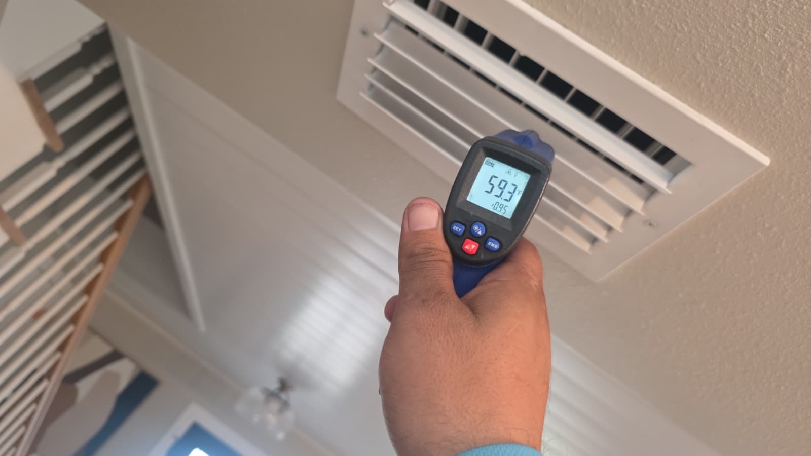 Temperature gun measuring air vent output in Tampa, FL 33615.