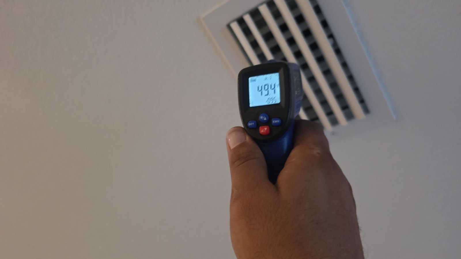 Technician measuring temperature at air vent with infrared thermometer in Palm Harbor, FL 34684.