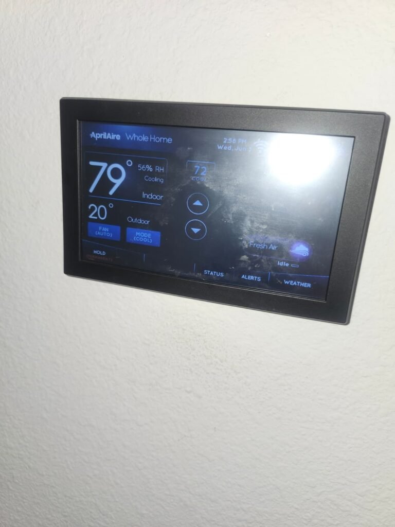 An AprilAire whole-home thermostat reading 56% indoor humidity in Tampa, FL 33613.
