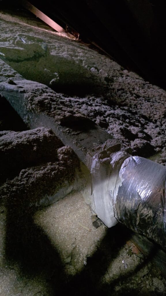 A flex duct run buried in blown-in insulation in an attic in Tampa, FL 33603.