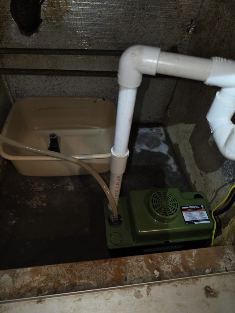 A condensate pump and its drain lines in a utility area in Hudson, FL 34667.