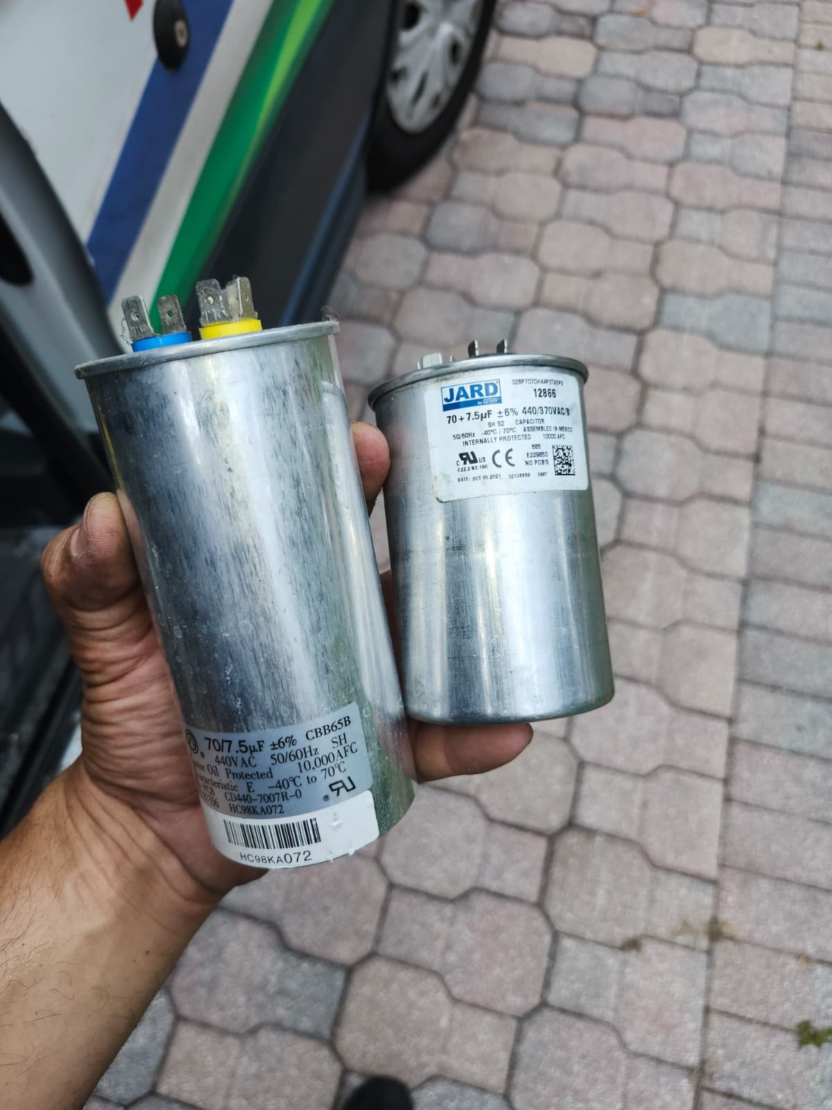 Tampa, FL 33647 capacitor replacement. Old vs. new capacitors in hand.