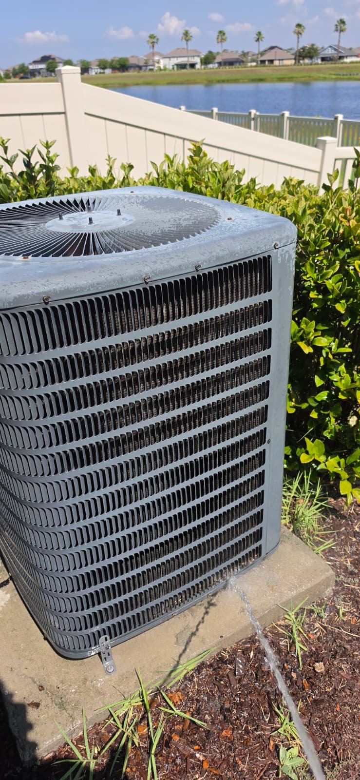Cleaned outdoor AC unit with water runoff in Riverview, FL 33579.