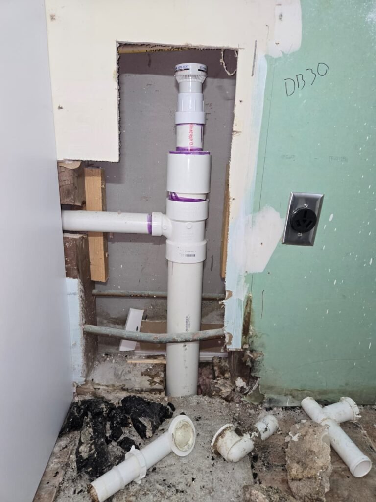 New PVC drain pipe and fittings in an open wall during a drain replacement in Tampa, FL 33611.