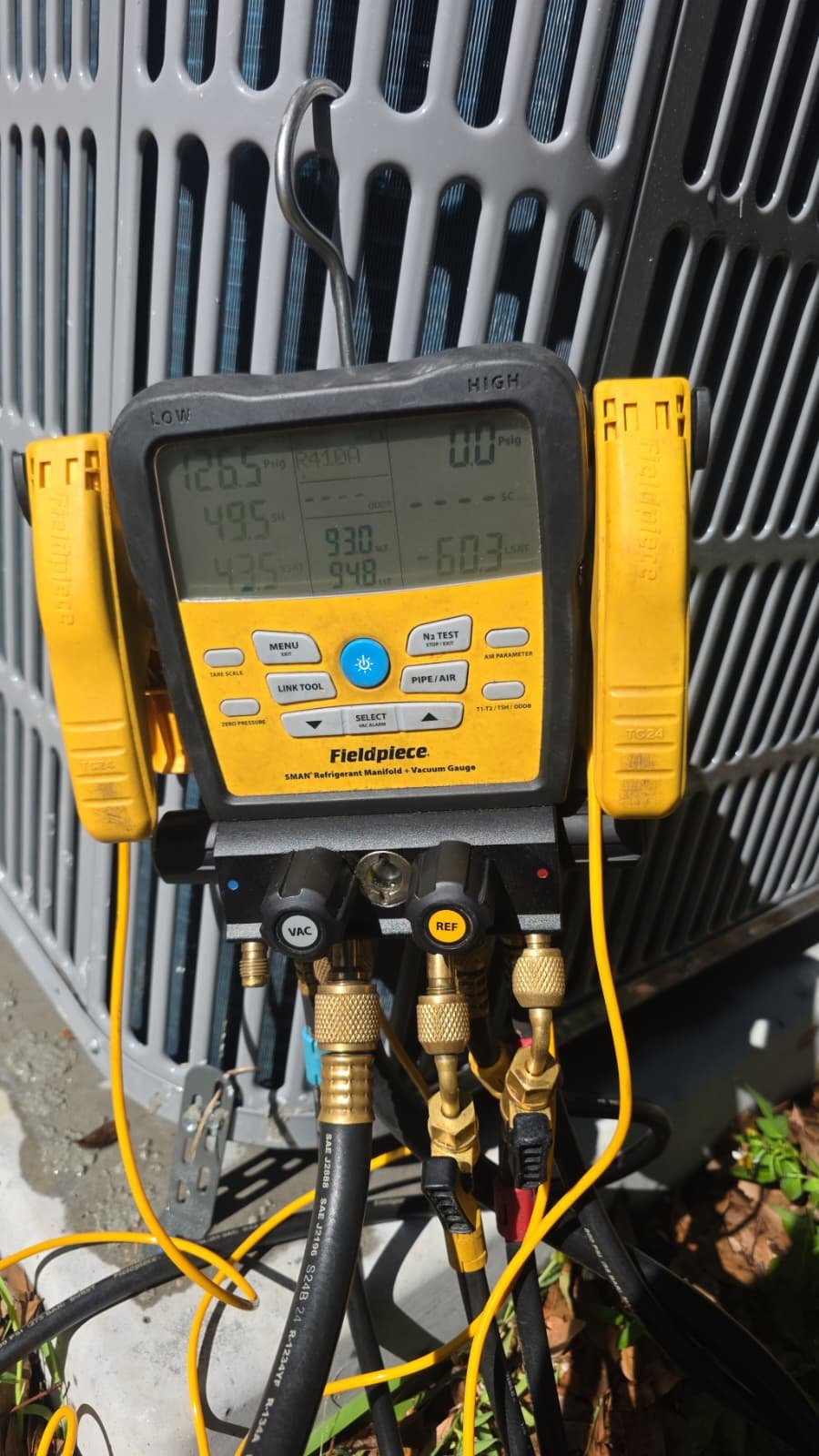 Fieldpiece digital manifold gauge attached to an AC unit in Tampa, FL 33610.