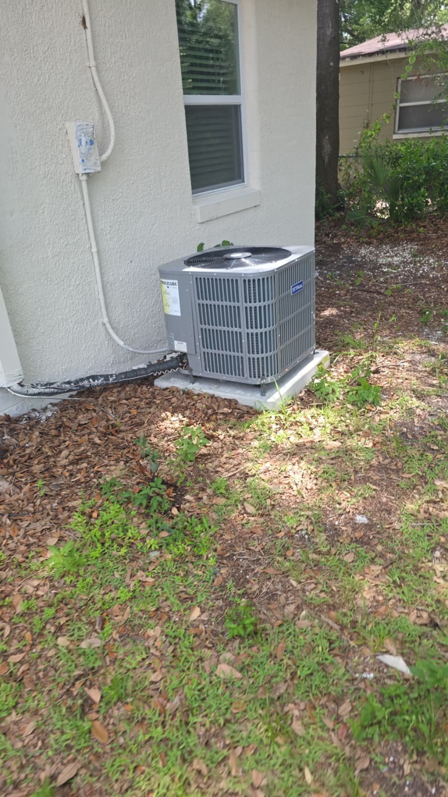 Air conditioning unit installed outside a house on a concrete pad in Tampa, FL 33610.